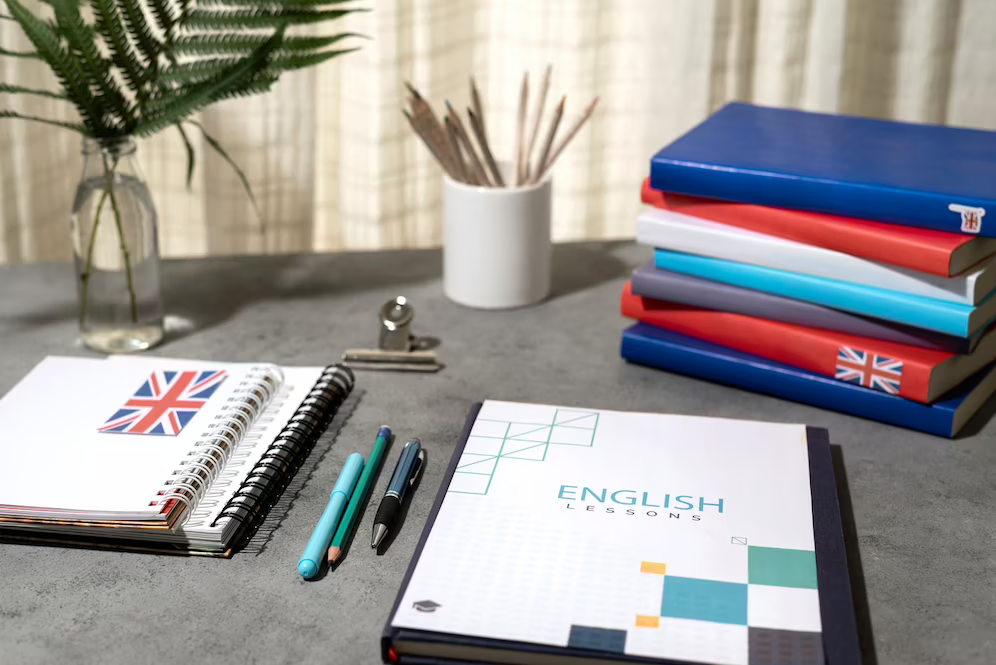 Stacks of English books on a table, depicting a productive working space for TOEFL exam preparation.