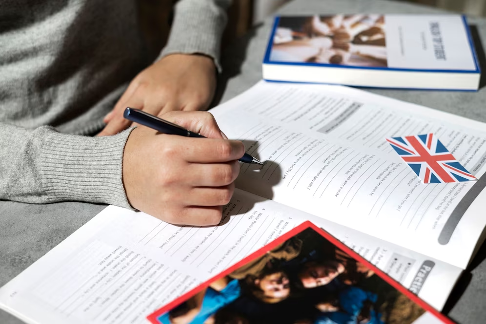 “English language books and a notebook on a table suggesting TOEFL exam preparation.”