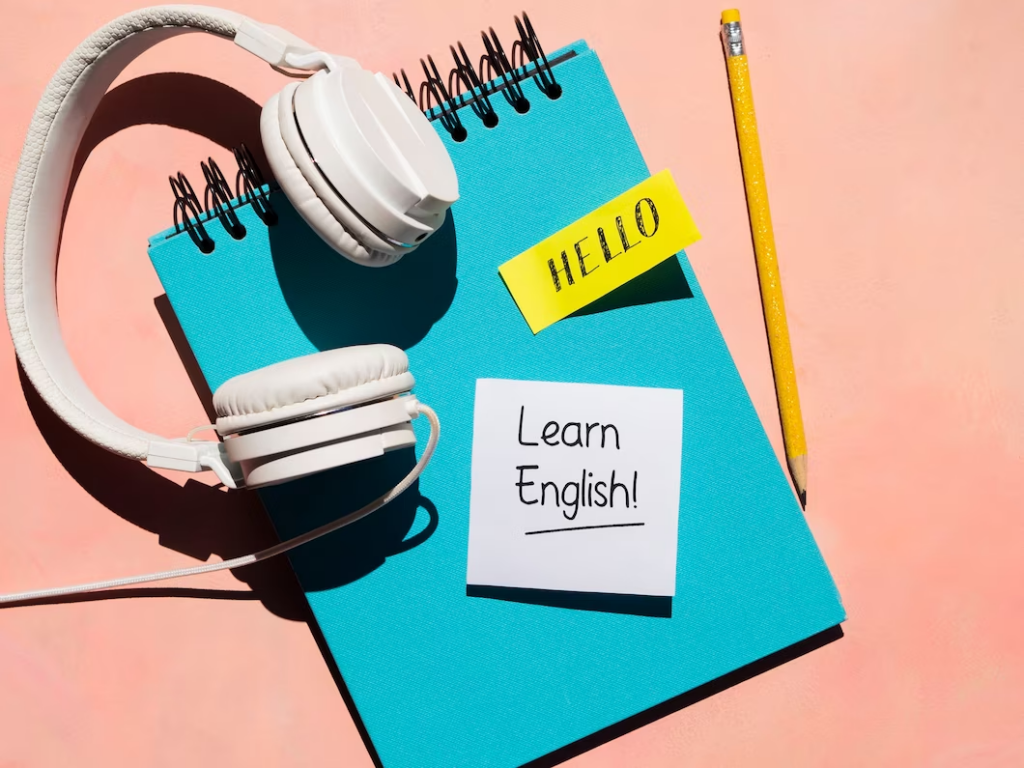 "TOEFL listening test prep: Headphones on a table, study materials in the background."