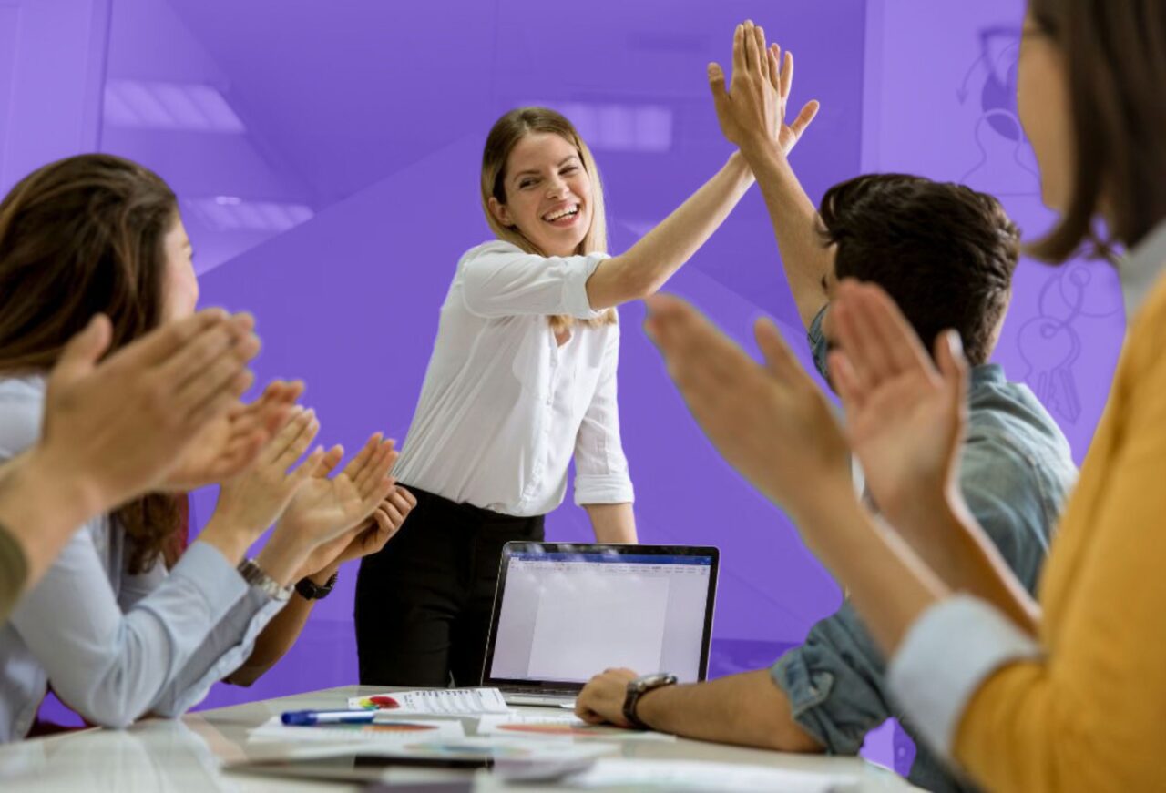 Students celebrating teamwork success with a high-five during a business and entrepreneurship programme