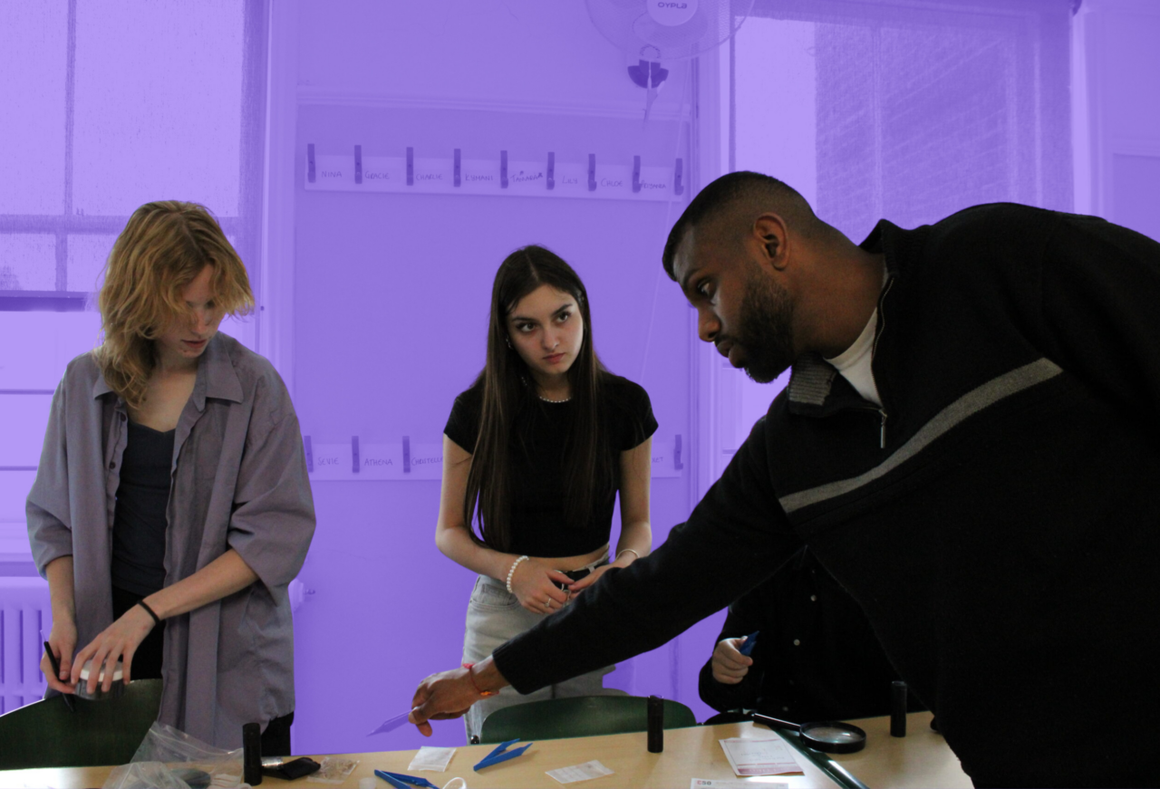 Students taking part in an investigative criminology workshop with a tutor, analysing evidence and learning practical forensic skills