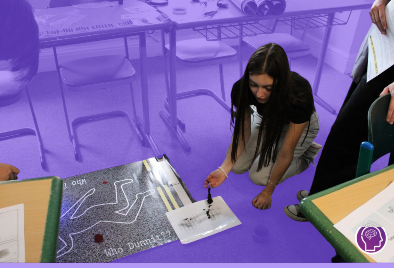Student examining evidence during a realistic forensic crime scene simulation in a criminology classroom